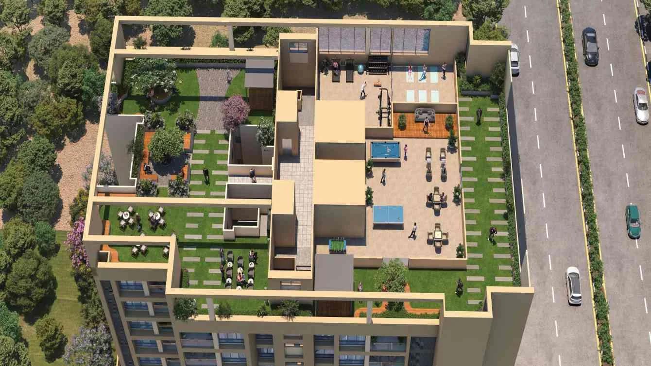 Aerial view of the rooftop gardens and seating beside a main road at Sky Meridian, Tathawade