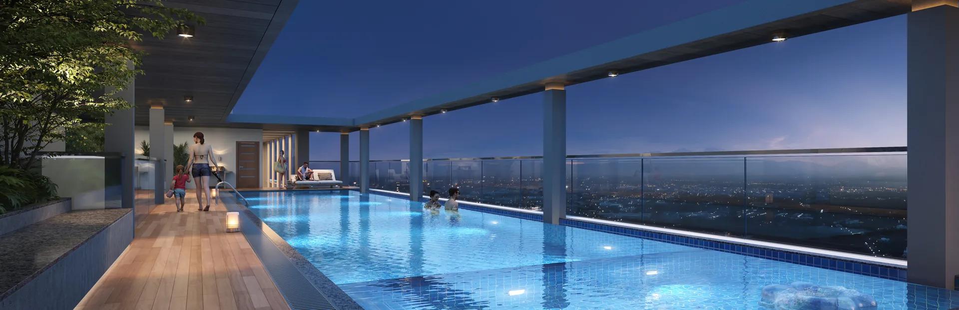Swimming pool with an infinity edge overlooking the city at dusk at Dream Delmont, Bavdhan